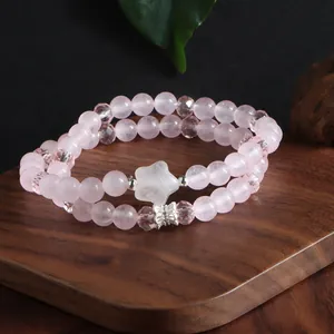 Gros plan d'un bracelet en quartz rose à deux rangs avec une pierre étoile et un papillon