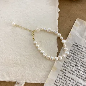 Detailed view of elegant baroque pearl necklace featuring a golden adjustable clasp