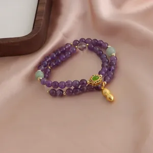 Dettaglio ravvicinato del bracciale a due fili in ametista naturale con ciondolo arachide