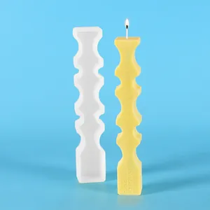 Vue détaillée d'une bougie pilier géométrique et de son moule en silicone blanc