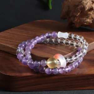 Detailed macro view of purple and clear crystal beads on a zen-style wooden surface.