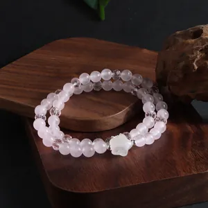 Gros plan sur un bracelet en quartz rose naturel à double couche avec sa breloque étoile