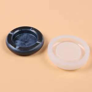 Detailed view of white silicone mold and a finished dark blue marble resin ashtray