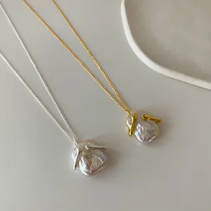Dettaglio di collane con perle barocche e un design unico ad abbraccio in oro e argento
