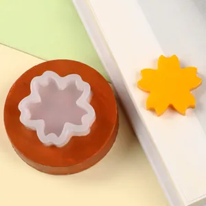 Close-up of a small flower daisy silicone mold shown with a yellow fondant decoration piece