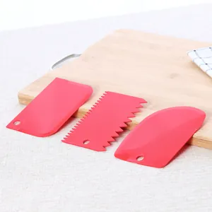 Set of 3 red plastic cake scrapers for baking and dough cutting on wooden board
