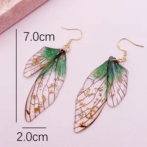 Close-up of green cicada wing earrings with gold foil detailing and 7cm length measurement