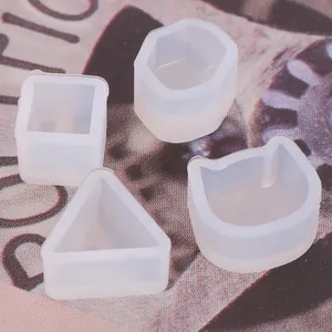 Détail des mini moules en silicone pour boucles d'oreilles en forme de chat, carré et triangle.