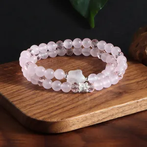 Détail du bracelet double couche en quartz rose naturel et cristal avec charme de cœur