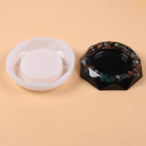 Detail view showing a white silicone ashtray mold next to a finished black resin piece.