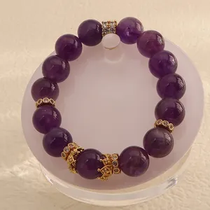 Detailed macro view of a natural Uruguay amethyst beaded bracelet featuring gold crown spacers