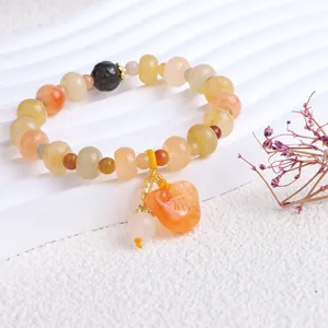 Detailansicht eines Armbands aus Jinsi-Jade mit ethnischen Kürbis- und Kürbisanhängern.