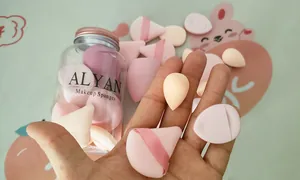 Primer plano detallado de mini esponjas de maquillaje y borlas de terciopelo en un tarro