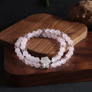 Vue détaillée d'un élégant bracelet en quartz rose à double rang sur un support en bois