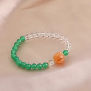 Detailansicht eines Naturkristallarmbands mit grüner Achat- und oranger Kürbisperle.