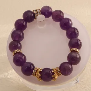 Detailed view of natural Uruguay amethyst beaded bracelet with sparkling gold charms