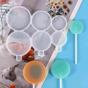 Détail d'un moule à sucettes en silicone à 6 cavités avec des bâtonnets de bonbons colorés.