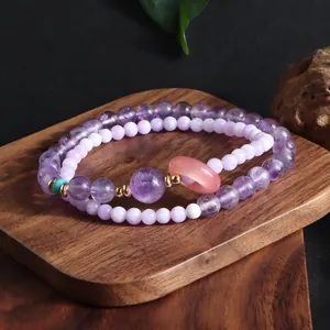 Detailed macro view of a double-layered purple crystal bead bracelet on a wooden tray