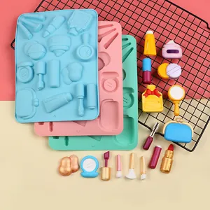 Detalle de molde de silicona con temática de maquillaje y piezas de fondant.