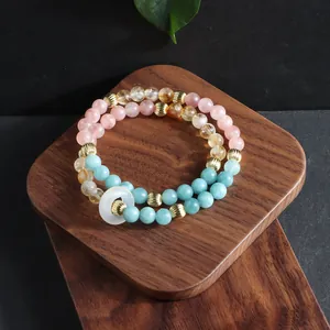 Macro detail of natural hematoid quartz and citrine multi-strand bracelet on wood