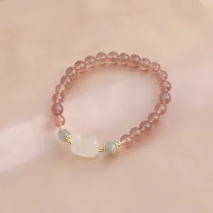 Natural strawberry quartz bracelet with carved white rabbit charm on pink silk