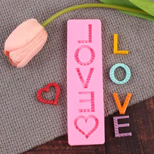 Κοντινό πλάνο ροζ καλουπιού σιλικόνης LOVE με δείγματα γραμμάτων από ζαχαρόπαστα