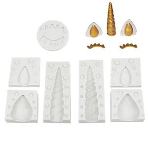 Detailed view of unicorn horn and ear silicone molds with finished gold parts