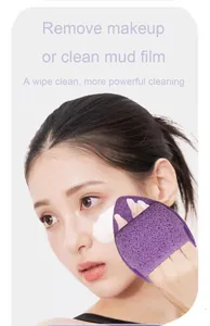 Close-up view of a model using a purple cleansing sponge puff to remove facial cleanser