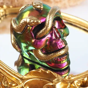 Detailansicht eines irisierenden Regenbogen-Schädels mit goldener Schlangen-Resin-Kunst