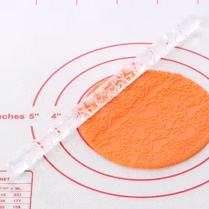 Close-up of heart pattern embossed on orange fondant using a clear acrylic rolling pin