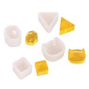 Détail montrant divers moules en silicone géométriques et en oreilles de chat pour résine.