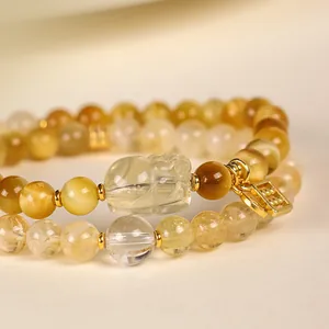 Double-strand yellow tiger eye and citrine beaded bracelet with clear carved Pixiu charm.