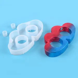 Primer plano del molde de silicona y del jarrón de resina de dos agujeros sobre fondo azul