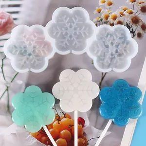 Close-up showing the intricate snowflake texture of the silicone mold and finished lollipops.