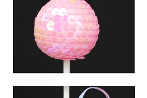 Detail shot of a sparkling pink sequin ball cake topper for birthday party decoration