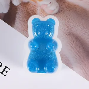 Primer plano de un dije de resina de osito azul con purpurina para fundas de móvil DIY