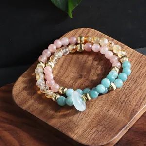 Close-up of multi-strand natural crystal bead bracelet with a white jade ring charm