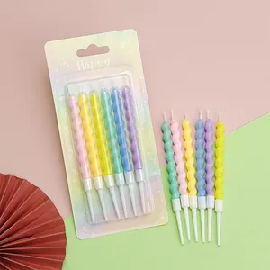 Close-up of colorful twisted spiral birthday candles with holders for party cake