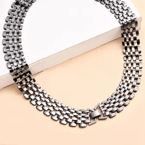 Macro detail of a wide gunmetal punk style chunky hollow link chain necklace.