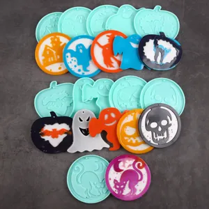 Collection of various Halloween silicone molds and finished resin pendants on grey background