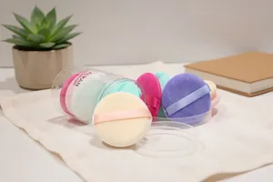 Detailed view of ALYAN multi-colored velvet powder puffs in clear storage cylinder.
