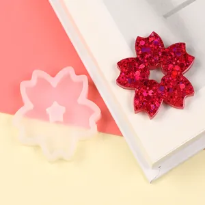 Detail of cherry blossom silicone mold and red glitter resin flower for DIY craft projects