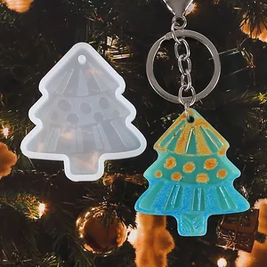 Close-up of Christmas tree resin mold and finished blue glitter keychain pendant