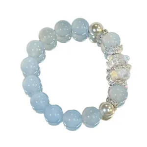 Handgefertigtes Armband aus blauen Kristallperlen mit Bärenanhänger und weißen Perlen