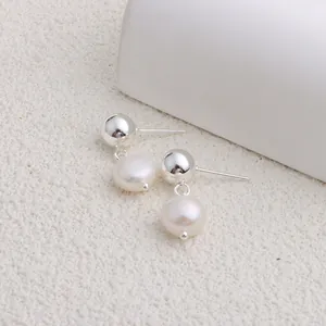 Dettaglio di eleganti orecchini a perno con perle naturali d'acqua dolce e finitura argento.