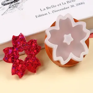 Close-up of cherry blossom silicone mold with a red glittery resin flower sample