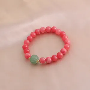 Nahaufnahme des Armbands aus rosa Rhodochrosit-Perlen mit grünem Achat-Kürbis-Anhänger