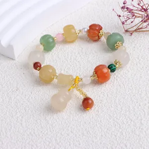 Detailansicht eines Perlenarmbands aus Naturjade mit Kürbisperlen und einem Kürbisanhänger.