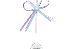 Close-up detail of a pastel blue and purple ribbon bow cake topper with a pearl center.