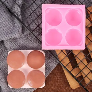 Roze siliconen mal voor 4 macarons getoond met zeepmonsters op een metalen rooster